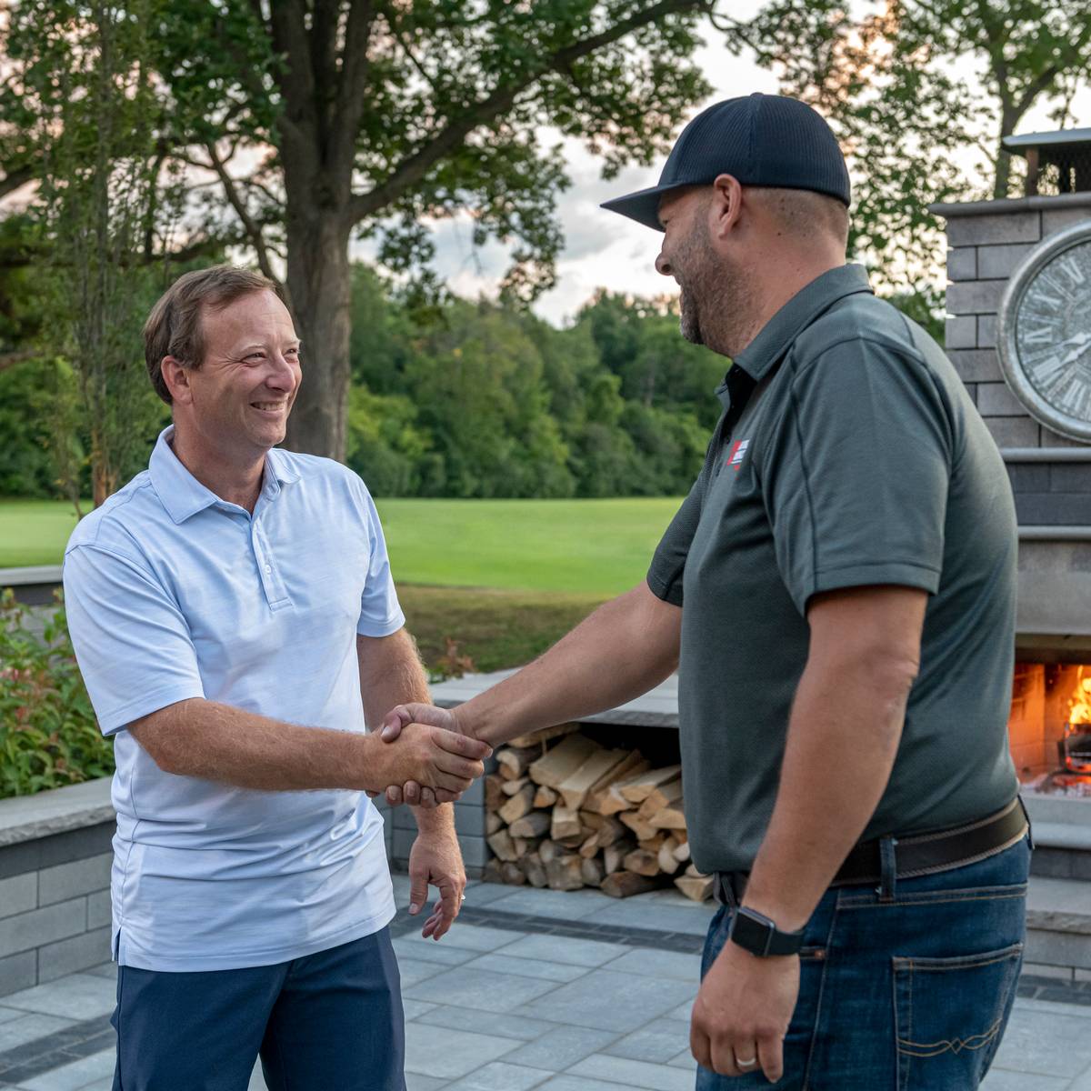 Image of a happy homeowner shaking hands with Unilock authorized contractor for concrete pavers