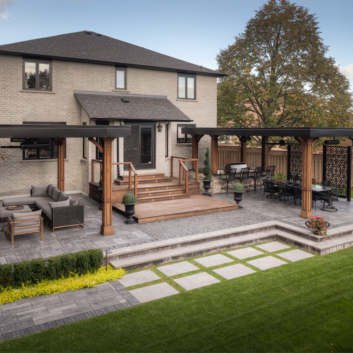 Raised patio paver design with outdoor kitchen and TV Wall
