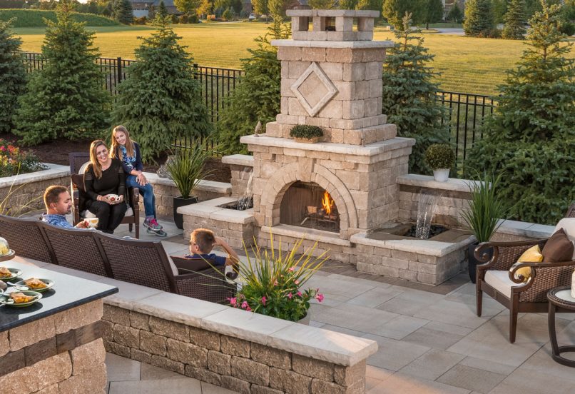 People Gathered on Unilock Patio by Tall Outdoor Fireplace