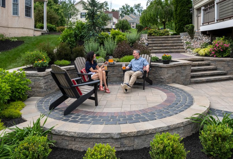 People Sitting on Circular Patio Design with Retaining Wall Plant Beds and Steps