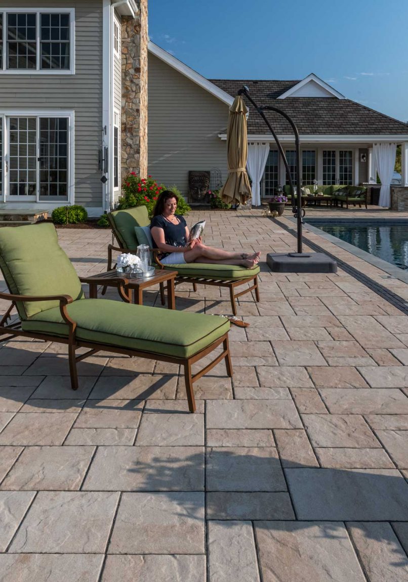 Person Lounging on Unilock Beacon Hill Flagstone Pool Deck
