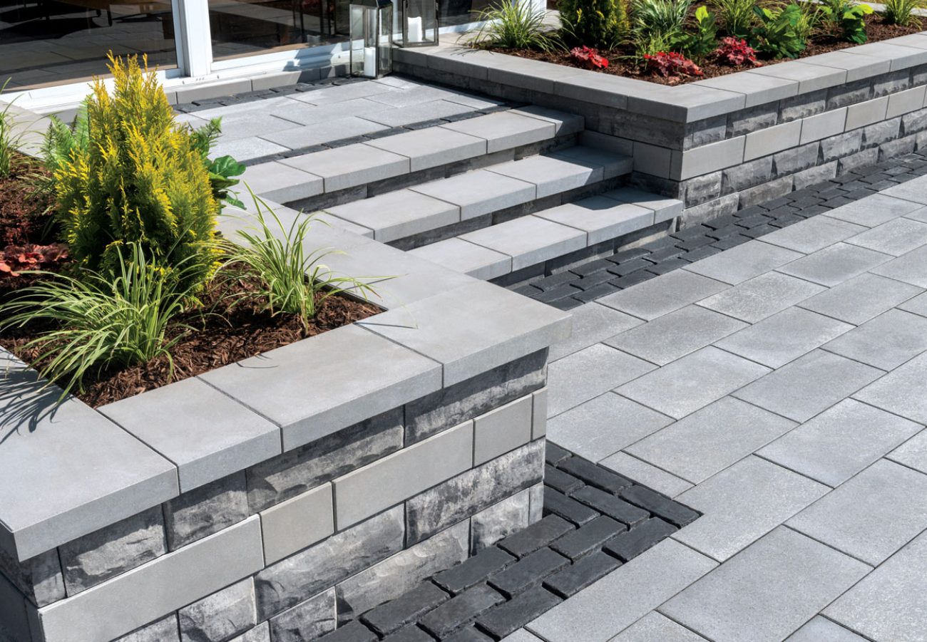 Unilock Steps from Entrance down to Patio with Decorative Retaining Wall Plant Beds