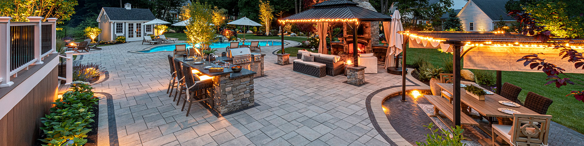 Unilock Outdoor Living Space with a Pool and Fireplace and Kitchen Island