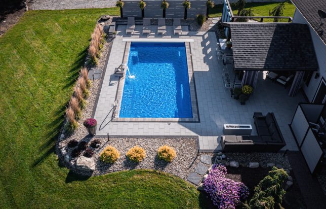 Birds eye view of backyard living space with pool and patio space with boarder