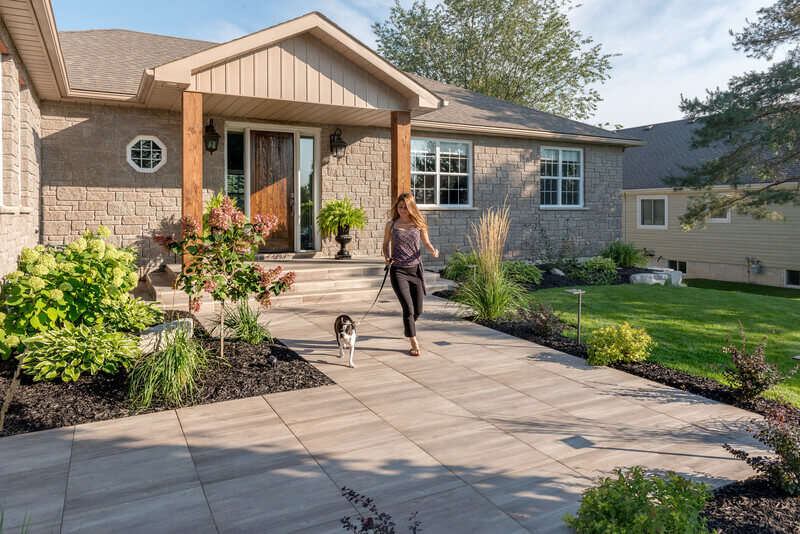 Person Walking Dog on Front Entrance Walkway with Unilock Pavers