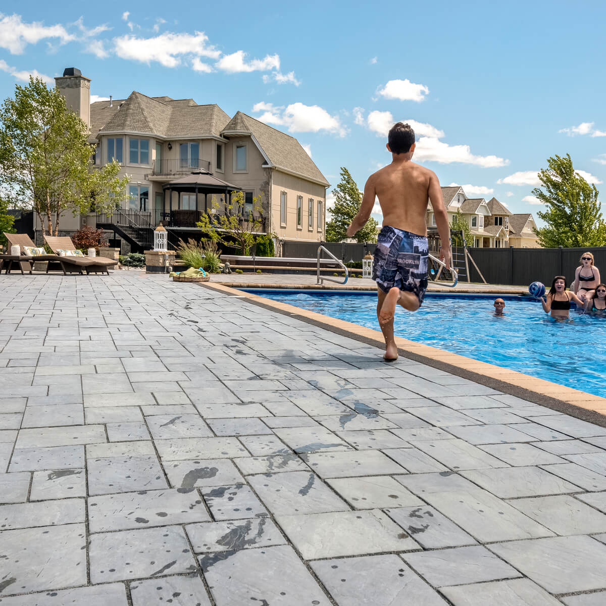 Person Running on Unilock Pool Deck with Coping to Jump into Pool