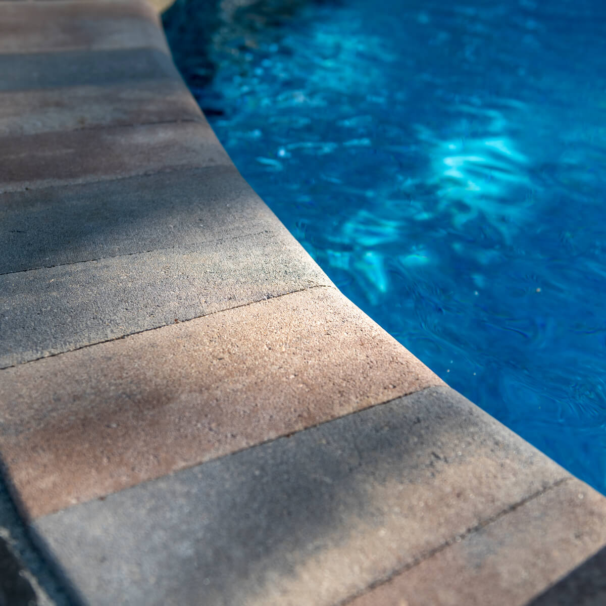 Close up of patio paver Pool Deck with Unilock Coping