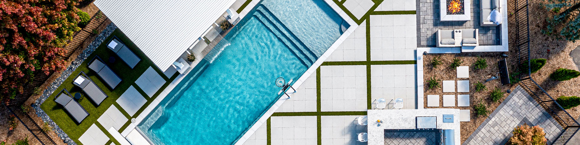 An aerial view of a swimming pool surrounded by patio pavers.