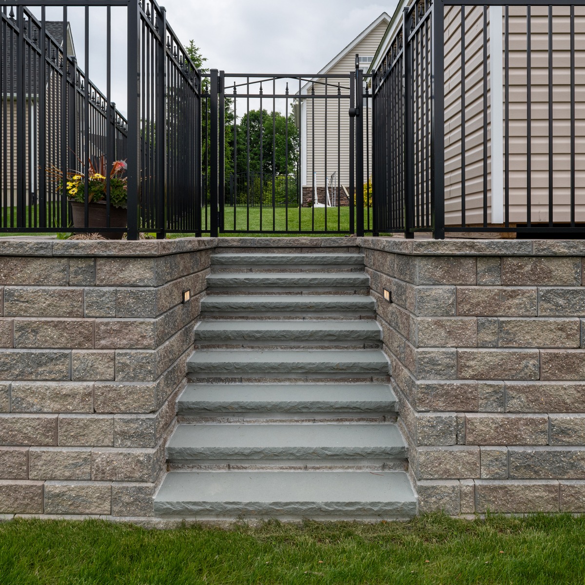 Retaining Wall Blocks and Fencing with Paver Stairs to Backyard
