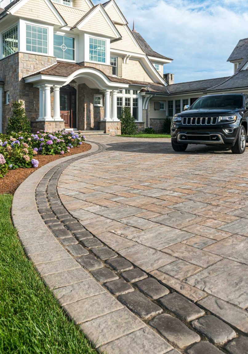 Unilock driveway and entrance with flagstone-textured Thornbury EnduraColor pavers, and heritage Courstone border