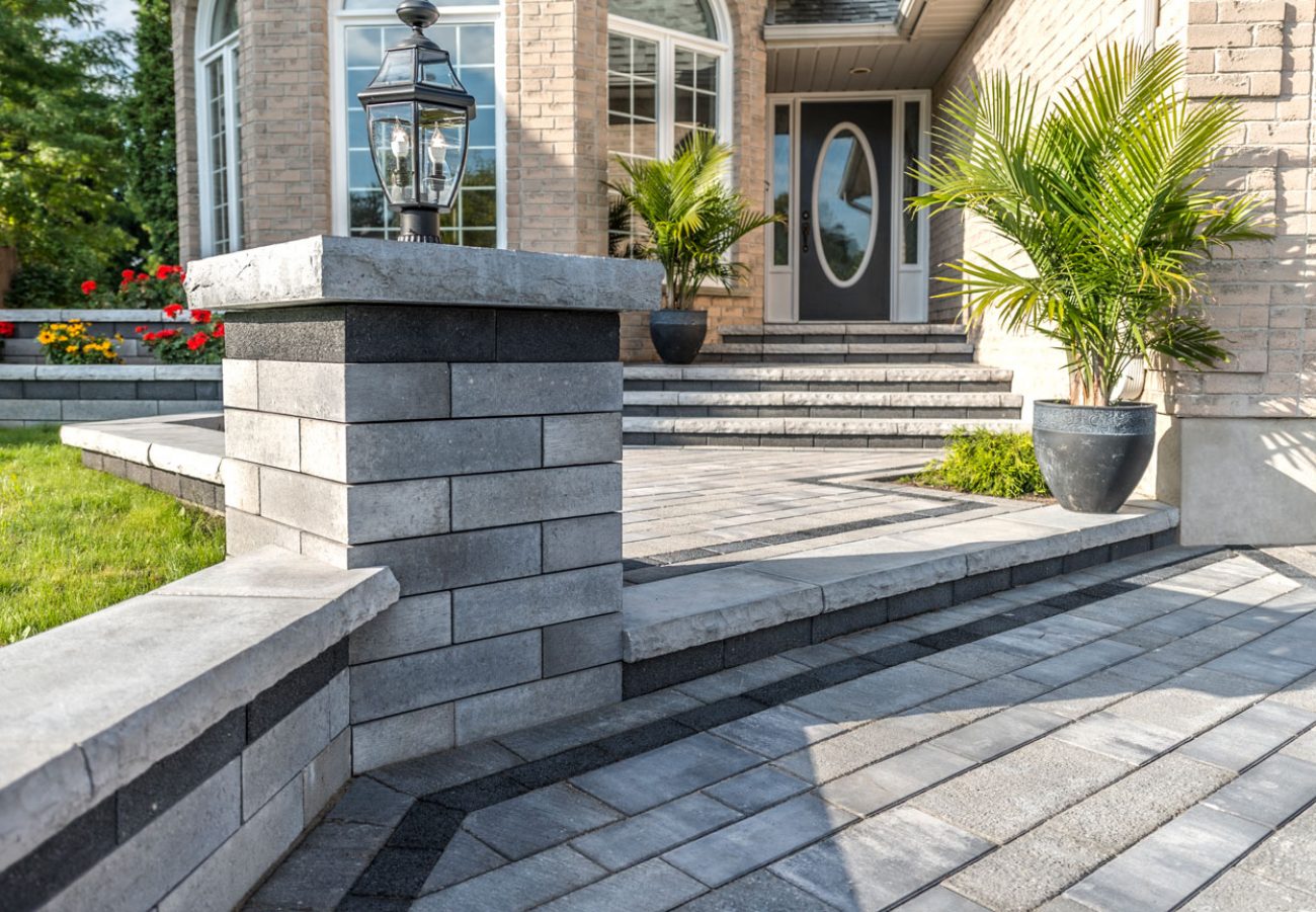 Contemporary Unilock entrance with Artline plank pavers, Ledgestone steps, and Lineo Dimensional Stone wall and pillar