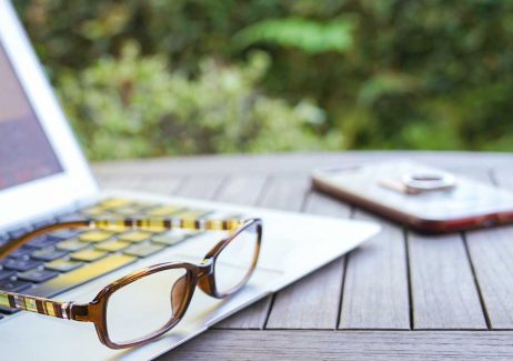 Close up of Computer and Glasses and Phone on Outdoor Table