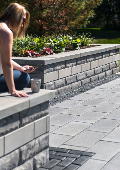 Person sitting on Unilock Retaining Wall