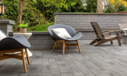 A patio with concrete pavers and a tree in the background.