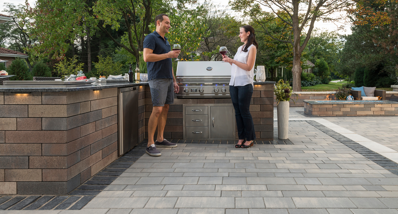 Couple on paver patio with outdoor kitchen