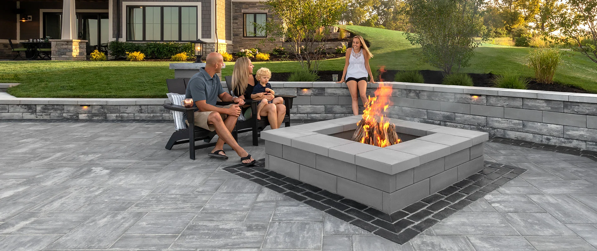 Family around fire pit with retaining wall