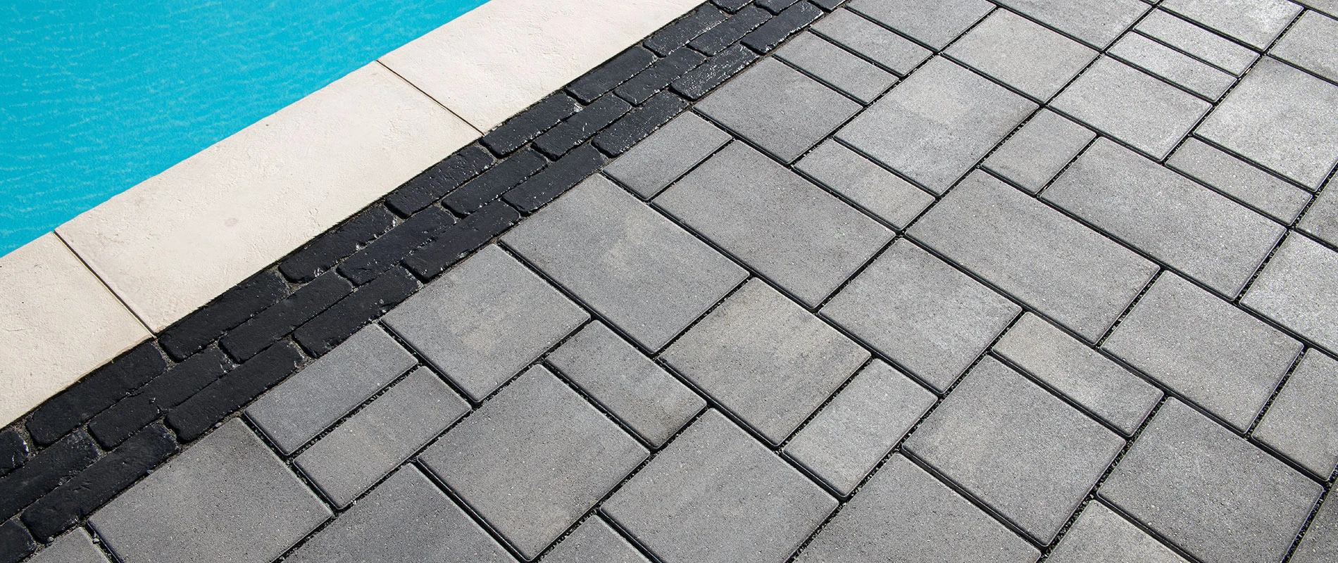 Permeable paver closeup shot next to pool coping