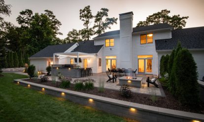 Paver patio with outdoor kitchen, fire pit with seating, and garden walls