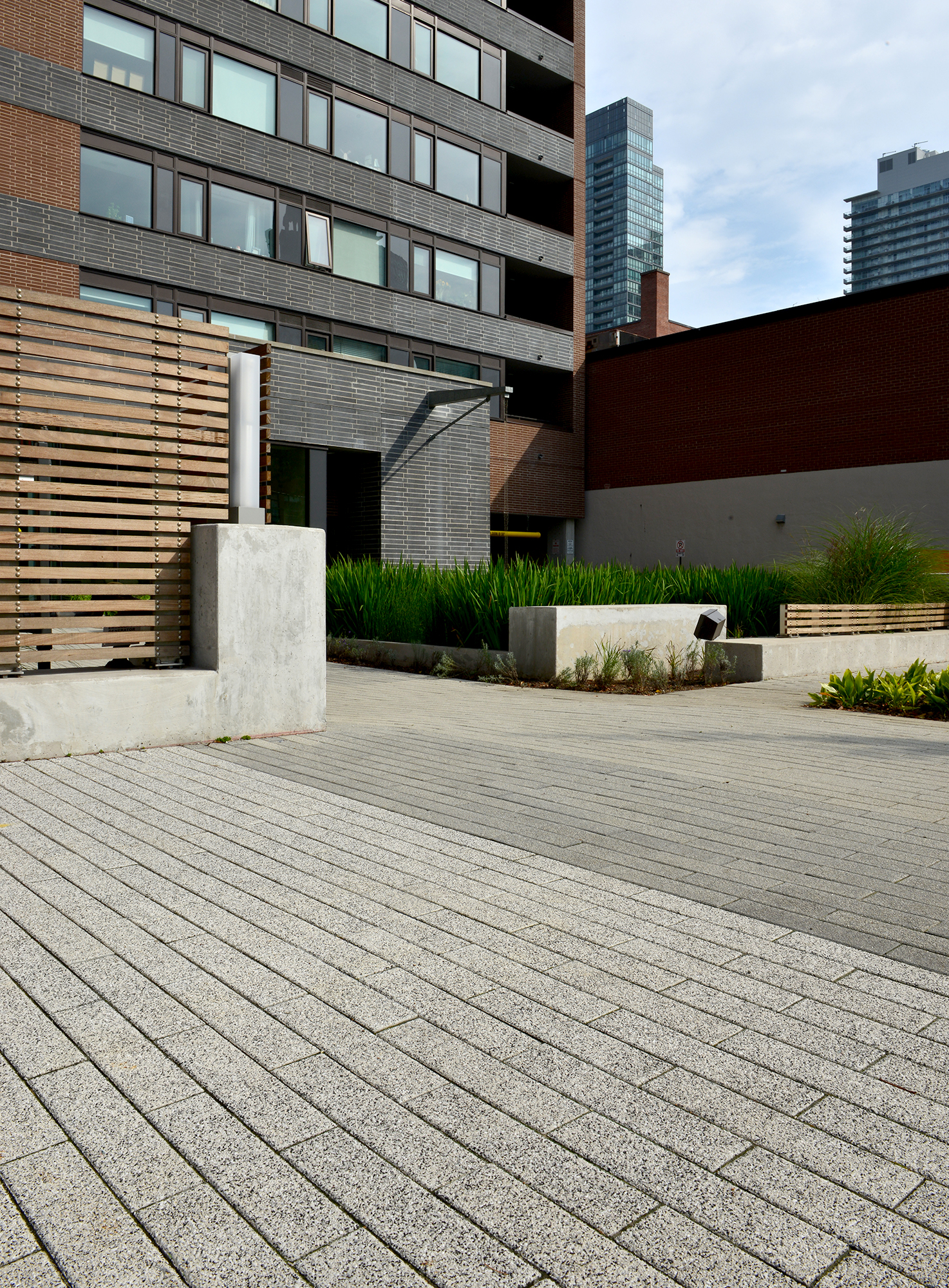 Unilock Promenade Plank pavers in a speckled Umbriano finish create a driveway for 400 Wellington Condominium in Toronto Ontario.