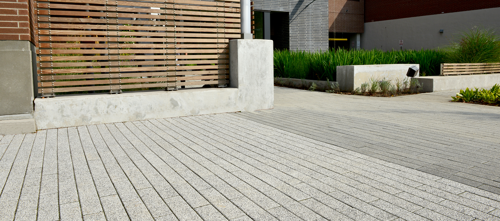 Unilock Promenade Plank pavers in a speckled Umbriano finish create a driveway for 400 Wellington Condominium in Toronto Ontario.