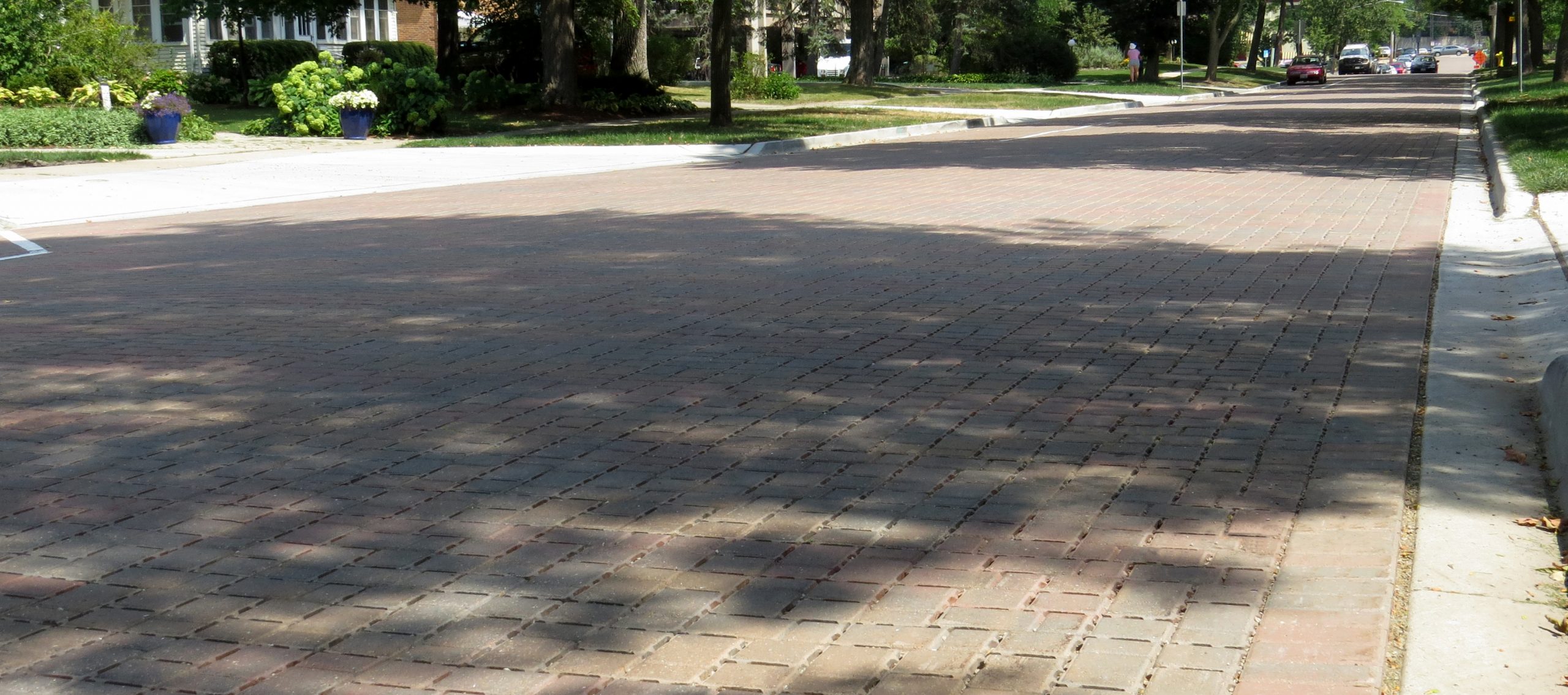 A warm hue of Eco-Optiloc pavers is used on the main roadway of Grove Street, with houses on both sides of the street.