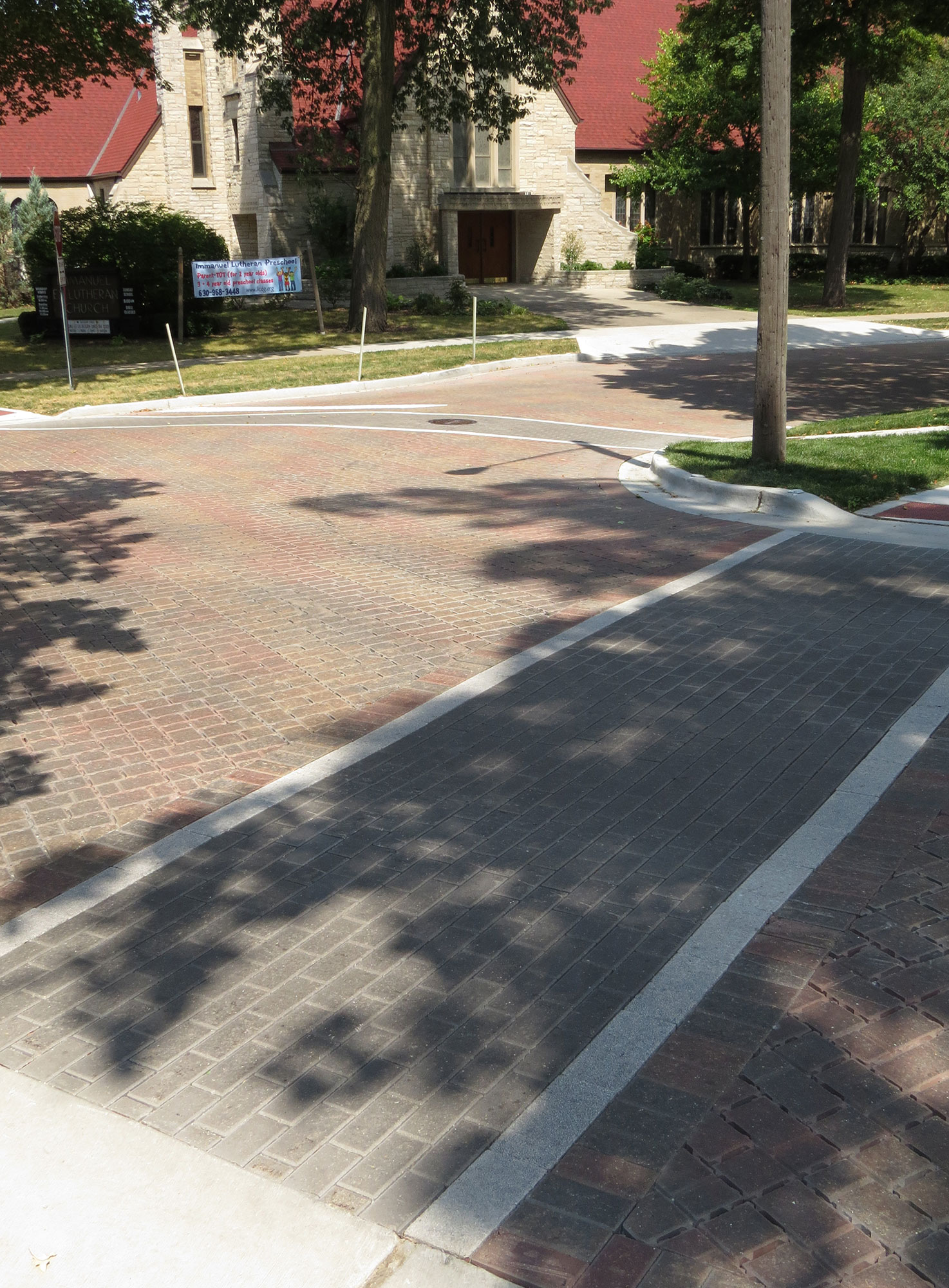 Grey Eco-Priora pavers form two distinct walkways, connecting intersecting street corners and disrupting a sea of red Eco-Optiloc.