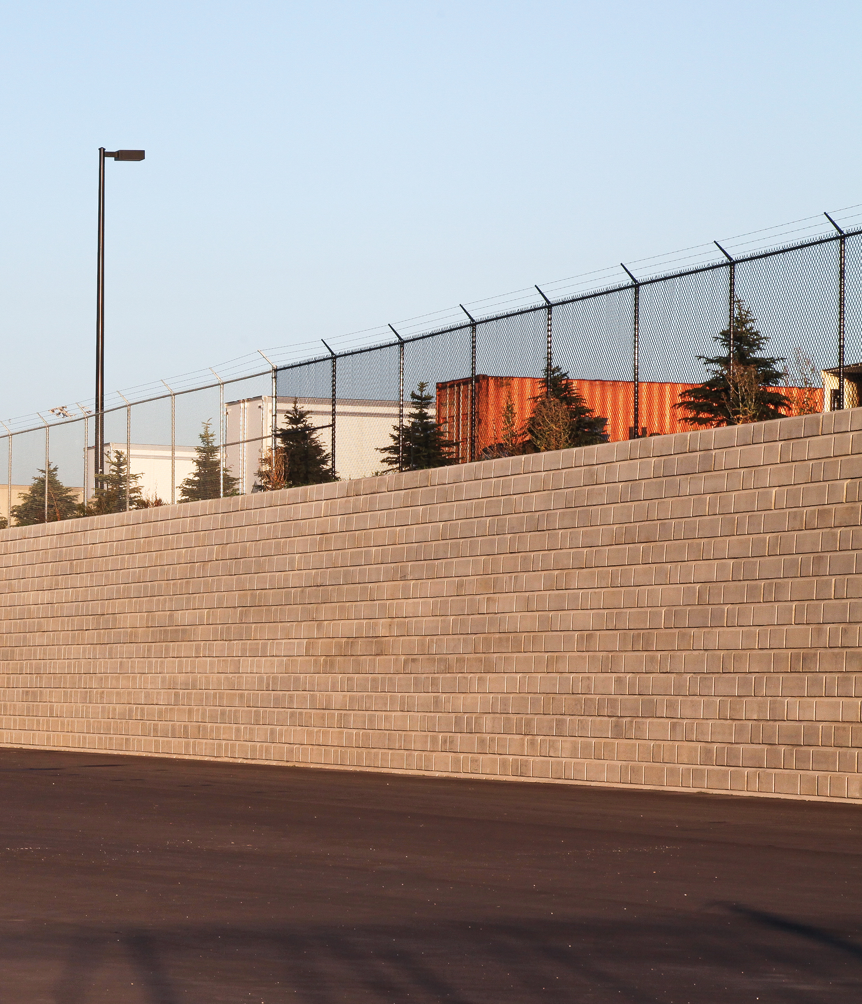 At the Home Depot Warehouse, a sizable DuraHold retaining wall and chain-link fence enclose an open parking area.