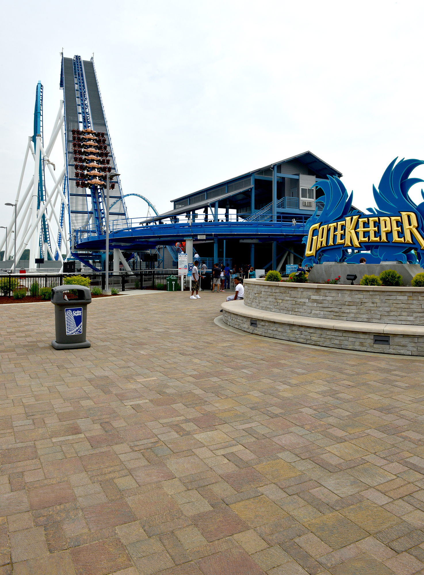 Il Campo pavers encapsulate the Gatekeeper rollercoaster signage, with several enclosed retaining walls lining the outer fence.