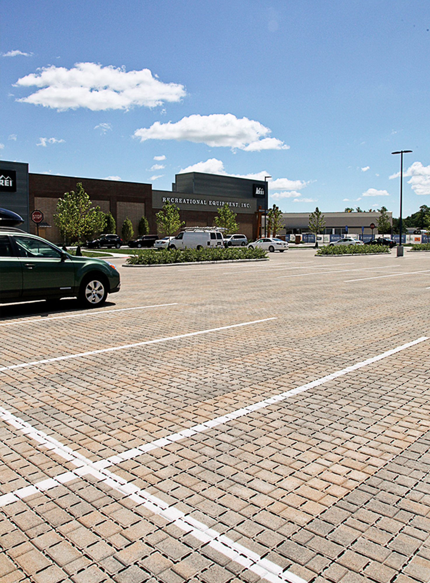 Painted white lines over Eco-Optiloc pavers delineate parking spaces at the Easton Gateway plaza between landscaping and garden beds.