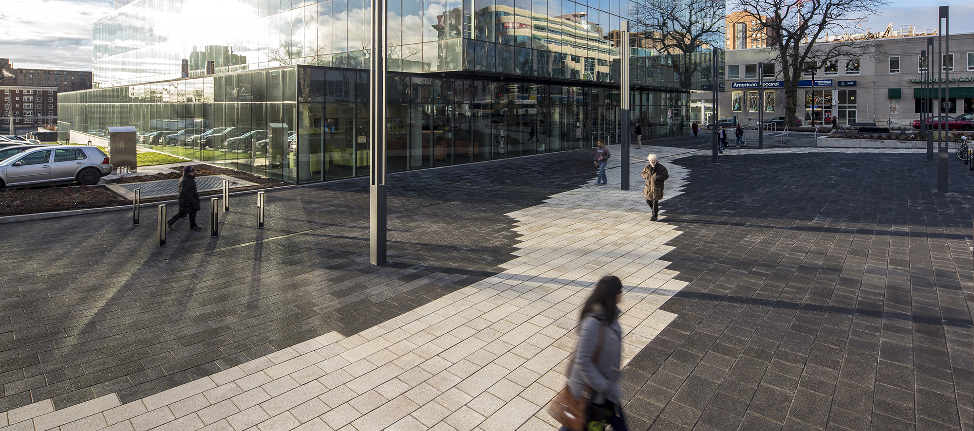 As visitors pass various garden islands with benches, black Series pavers highlight the Halifax library's contemporary glass architecture.