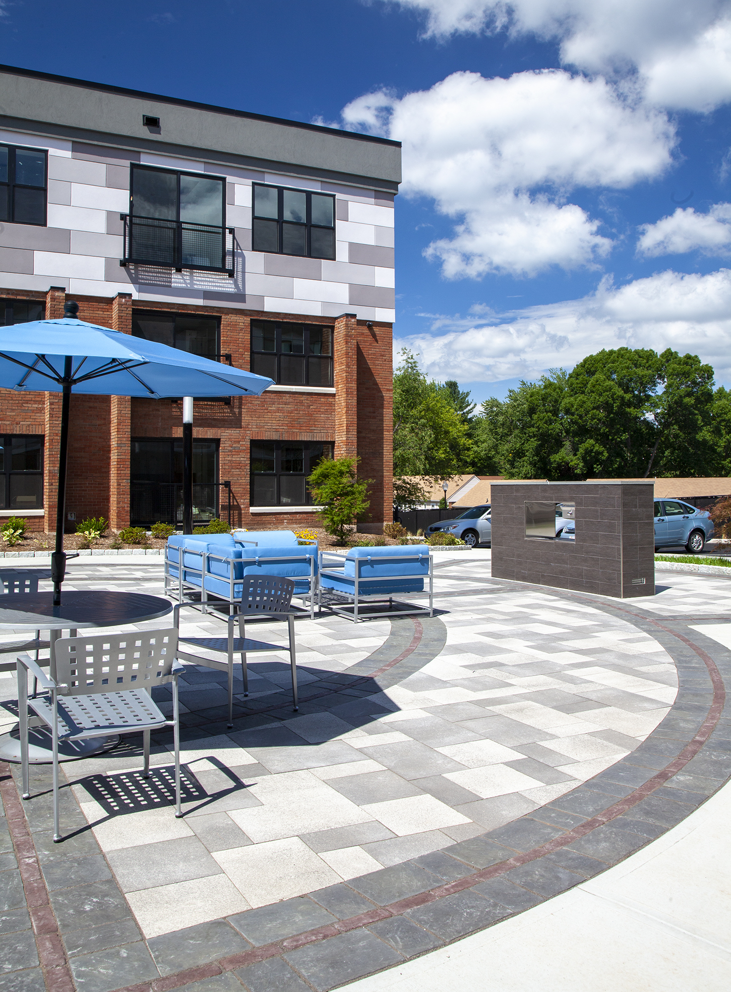 An apartment complex with an outdoor amenity space of Umbriano pavers with contrasting circular patterns of Copthorne and Richcliff.