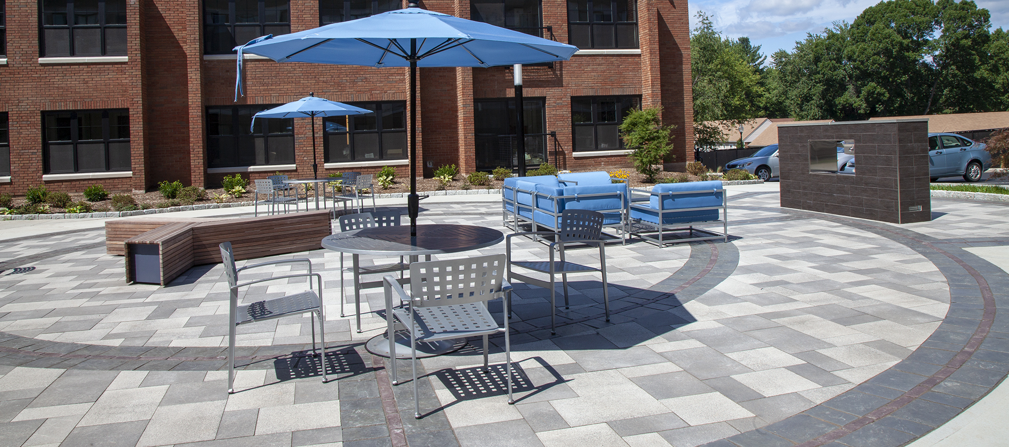 An apartment complex has an outdoor amenity space of Umbriano pavers with contrasting circular patterns of Copthorne and Richcliff.