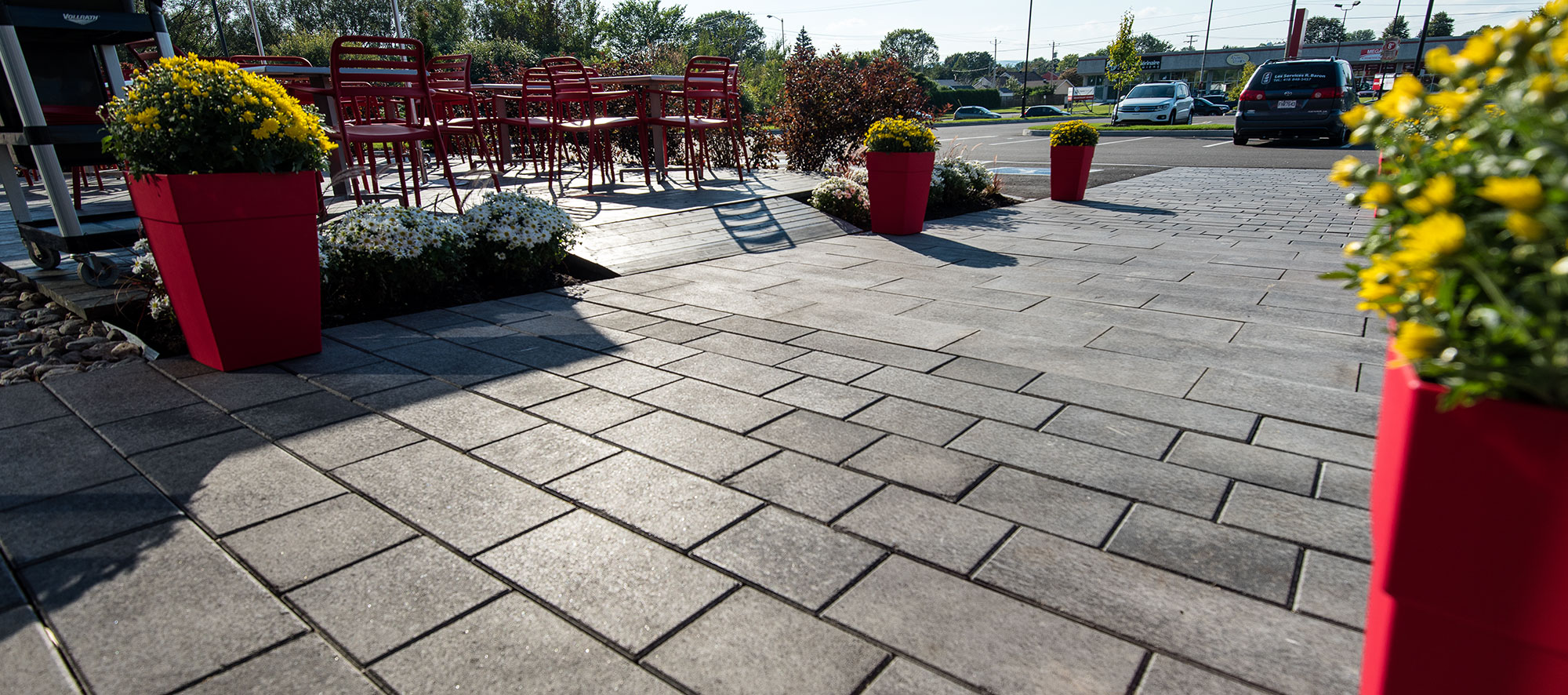Rectangular Artline pavers with a mottled Umbriano finish create a path that leads to a parking lot, past a seating area and landscaping.