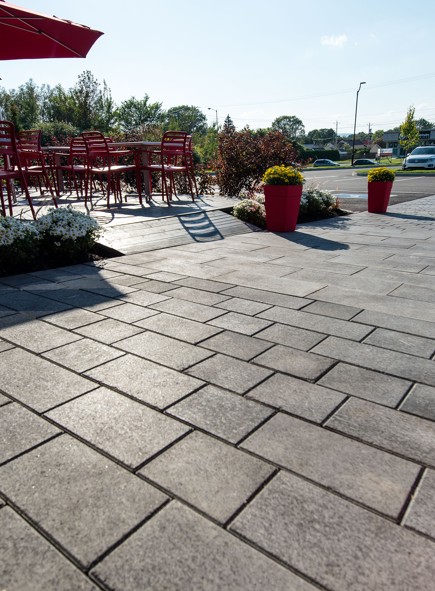Rectangular Artline pavers with a mottled Umbriano finish create a path that leads to a parking lot, past a seating area and landscaping.