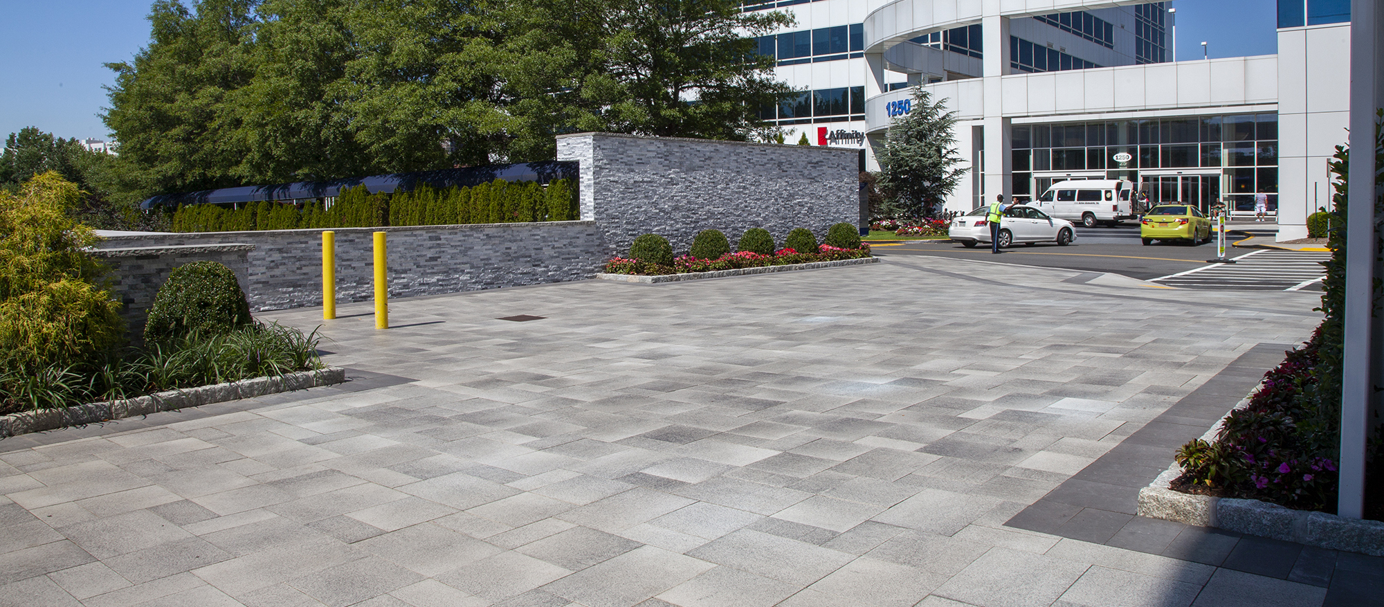 In front of the Hutchinson Metro Centre loading zone is a pedestrian area with multi-tone Umbriano pavers, a garden wall and landscaping.