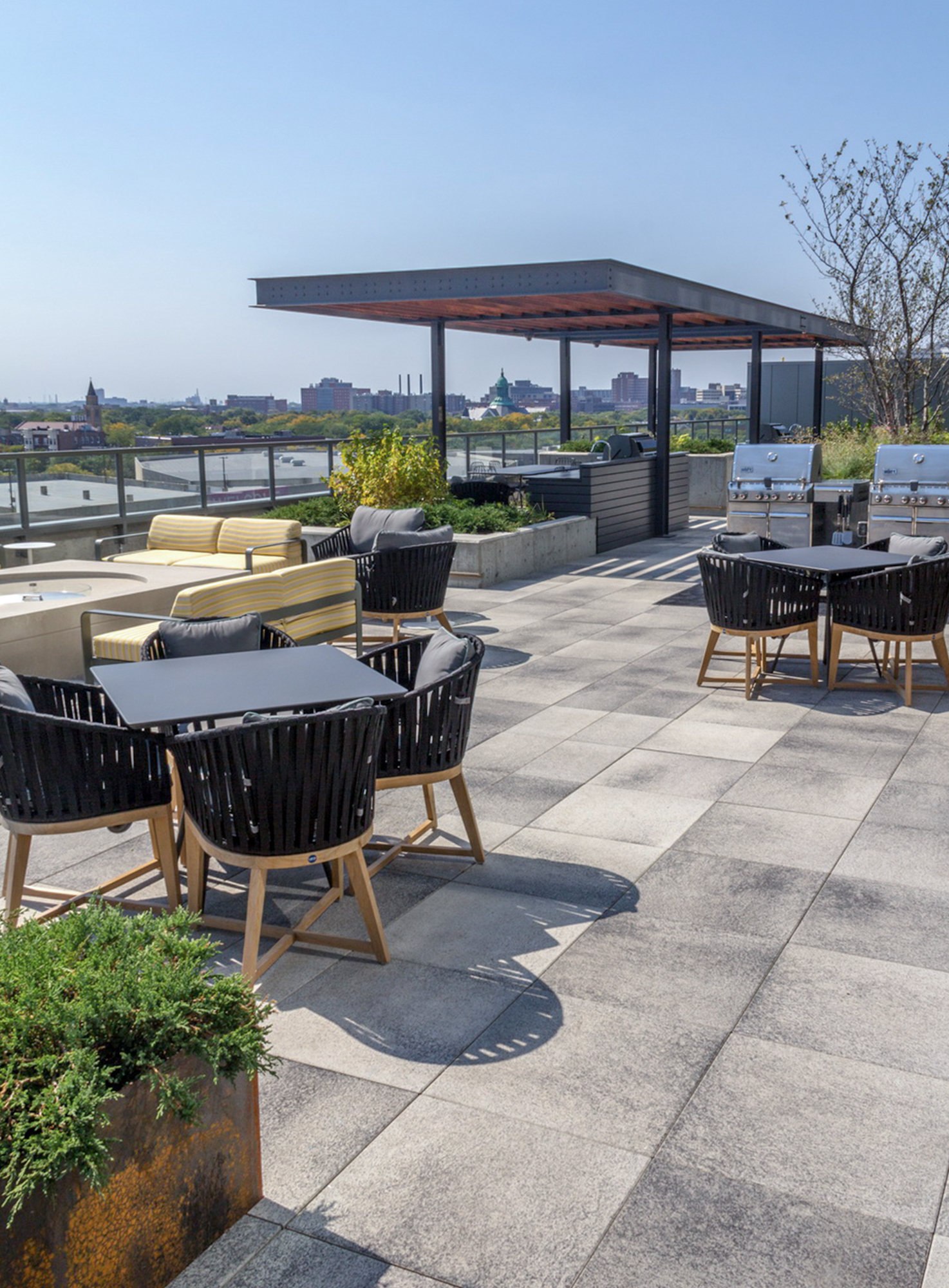 A roof deck overlooking the Chicago skyline features grey Umbriano slabs and outdoor amenities including an outdoor kitchen and BBQs.
