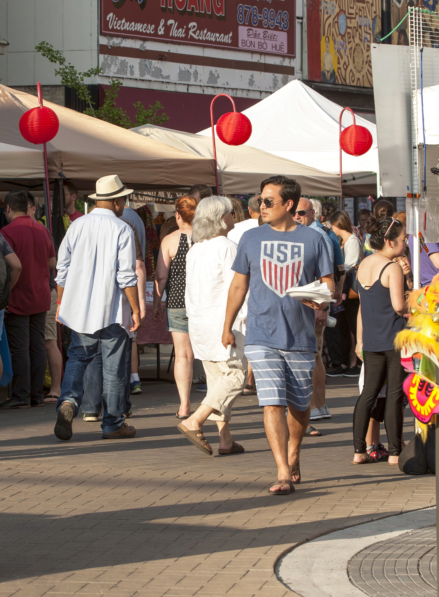 People shop at a busy outdoor market on a streetscape paved with Unilock Eco-Priora permeable pavers.