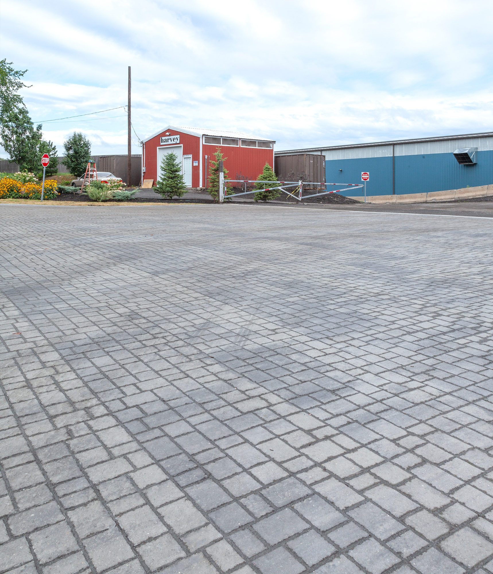 Faint tire tracks appear on the surface of grey Optiloc pavers outside of the E.L. Harvey & Sons industrial site.