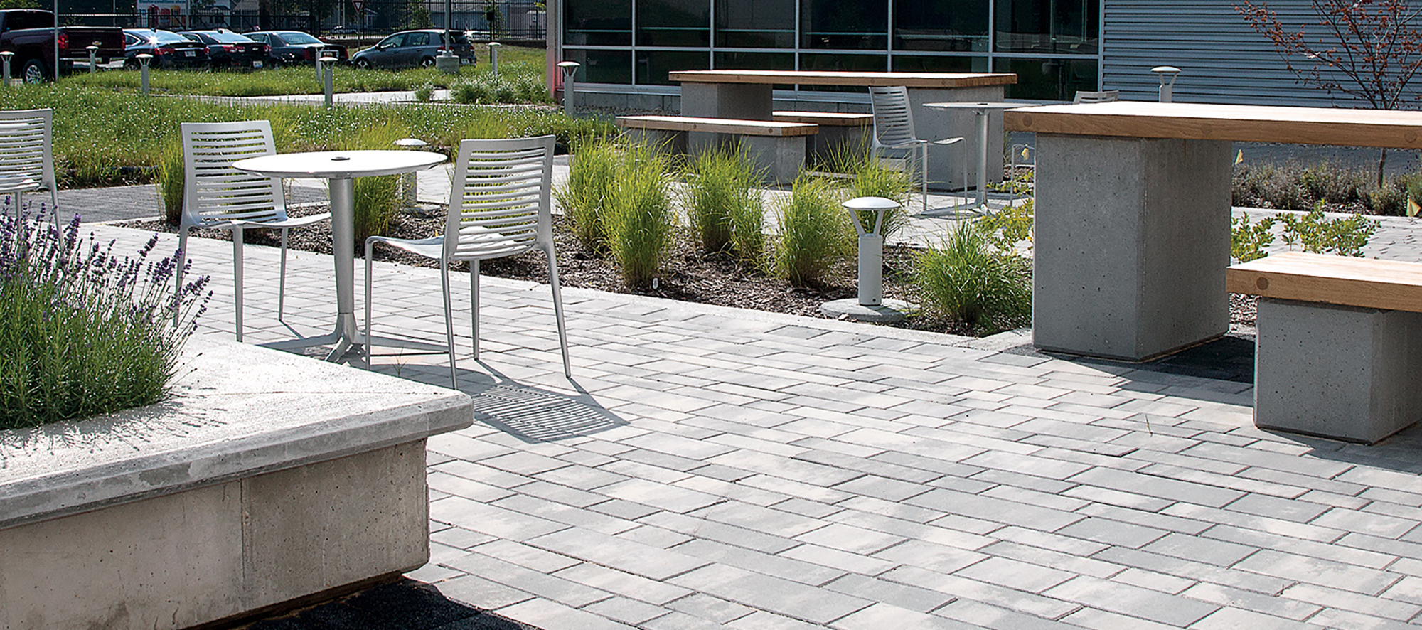 Unilock Il Campo and Artline pavers hold metal and wood tables, benches, and chairs at Holland Energy Park