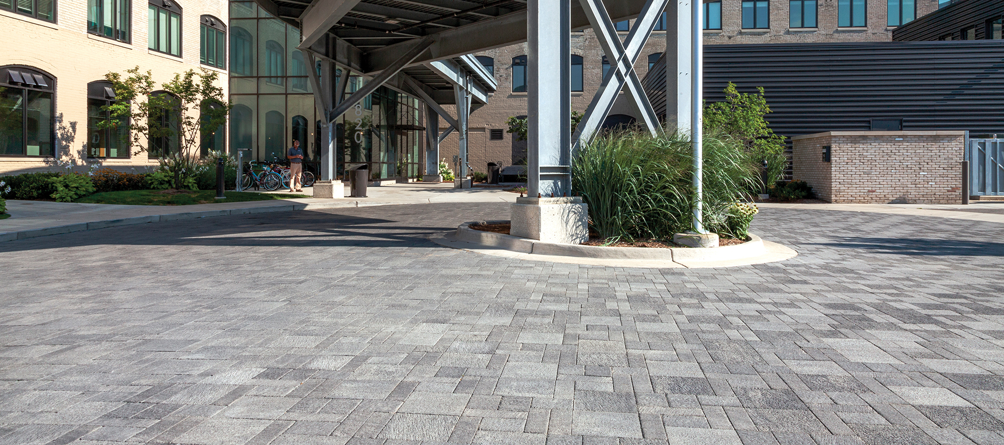 In front of 616 Lofts on Monroe is a circular driveway made from Unilock Il Campo pavers in shades of grey, and a loading shelter.
