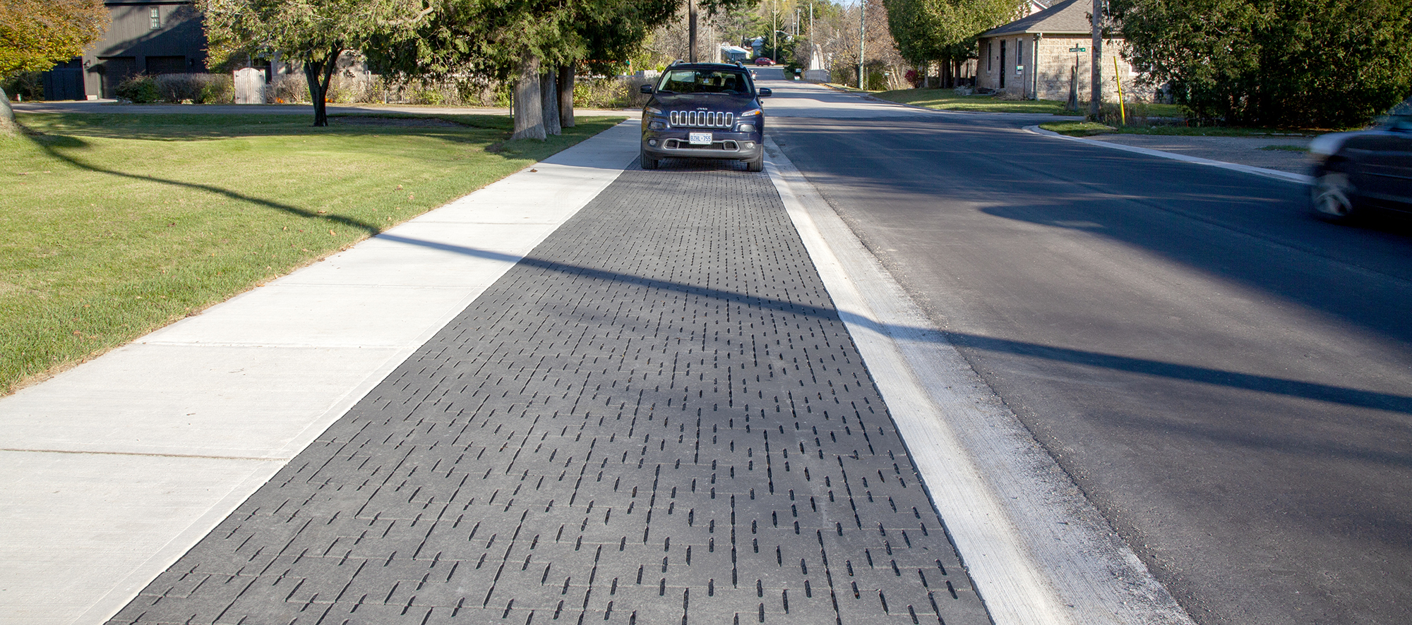 Parking lane on a residential street paved with Unilock Dura-Flow permeable pavers.