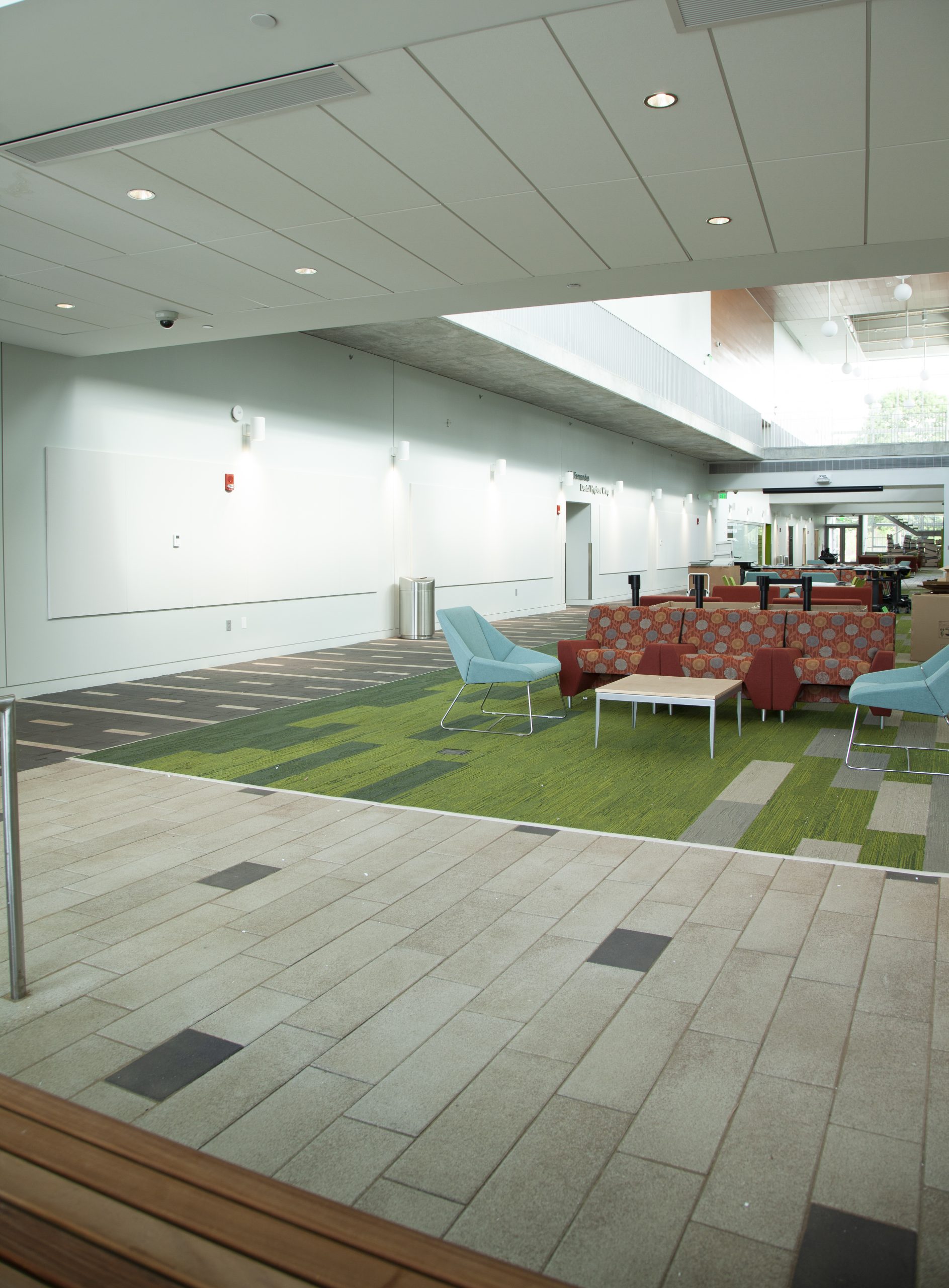 Promenade Plank Pavers delineate a path through a college building on the main floor, using bold stripe patterns in contrasting colors.
