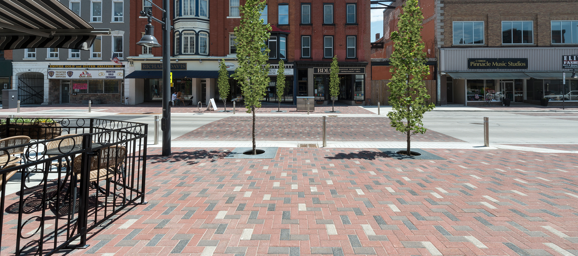 An old-fashioned streetscape with walkways and pedestrian areas made from multicolor Series pavers in a herringbone pattern.