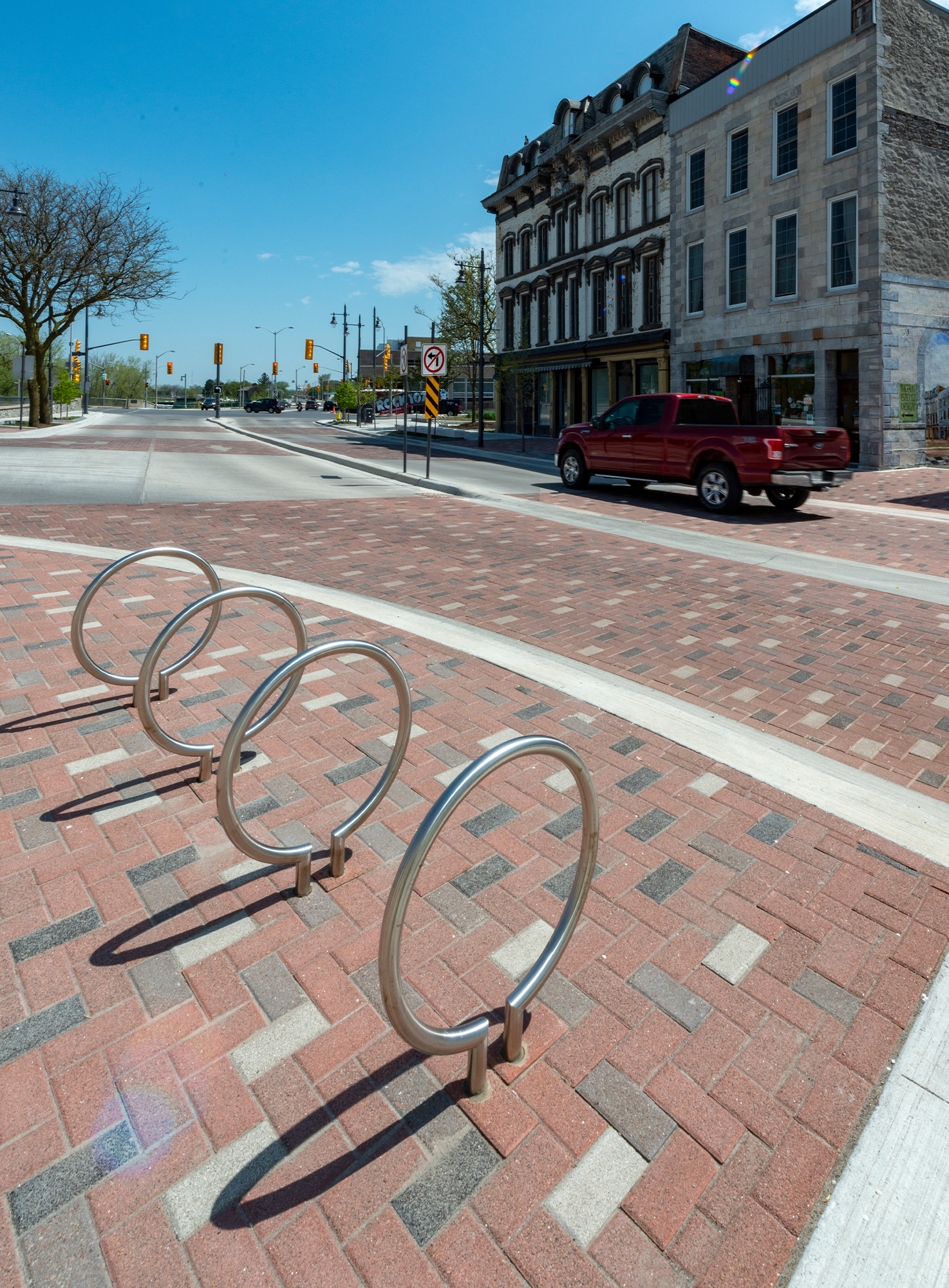 Bike racks sit on multicolor Series pavers that delineate pedestrian areas within a streetscape of a small historic town.