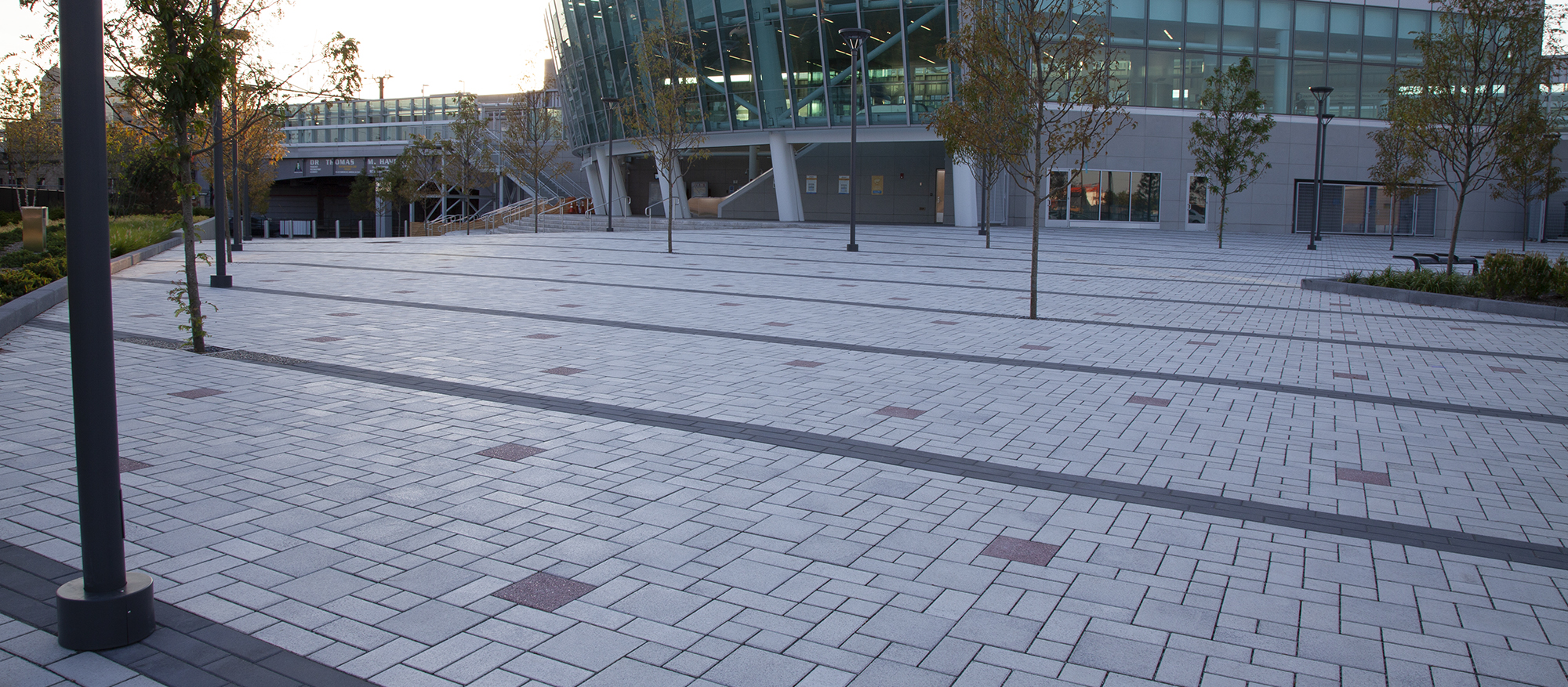 White Eco-Priora pavers are dotted with red square pavers, with black Eco-Promenade in diagonal paths along the Harrison Path Station plaza.