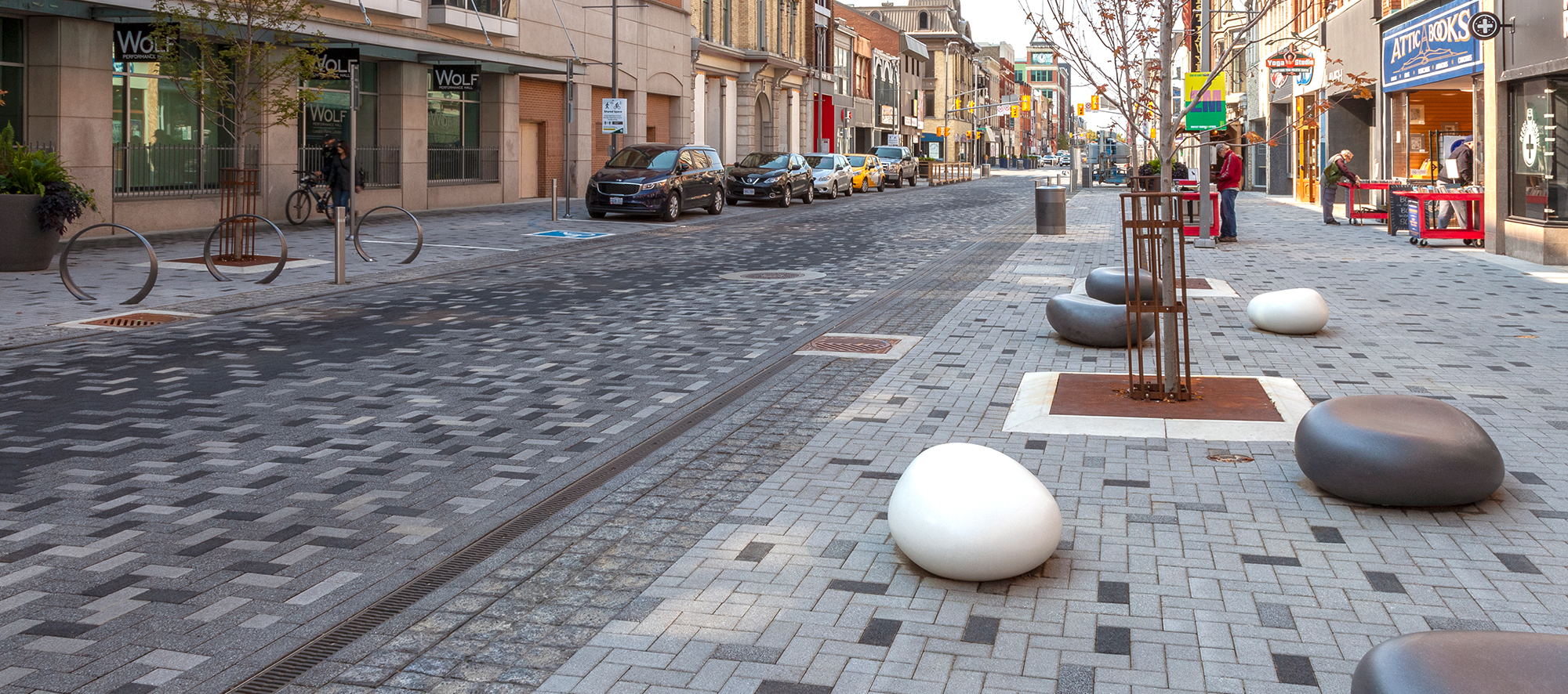 Dundas Place streetscape has Series pavers with alternating tones creating patterns, bike racks, and large smooth rocks to sit on.