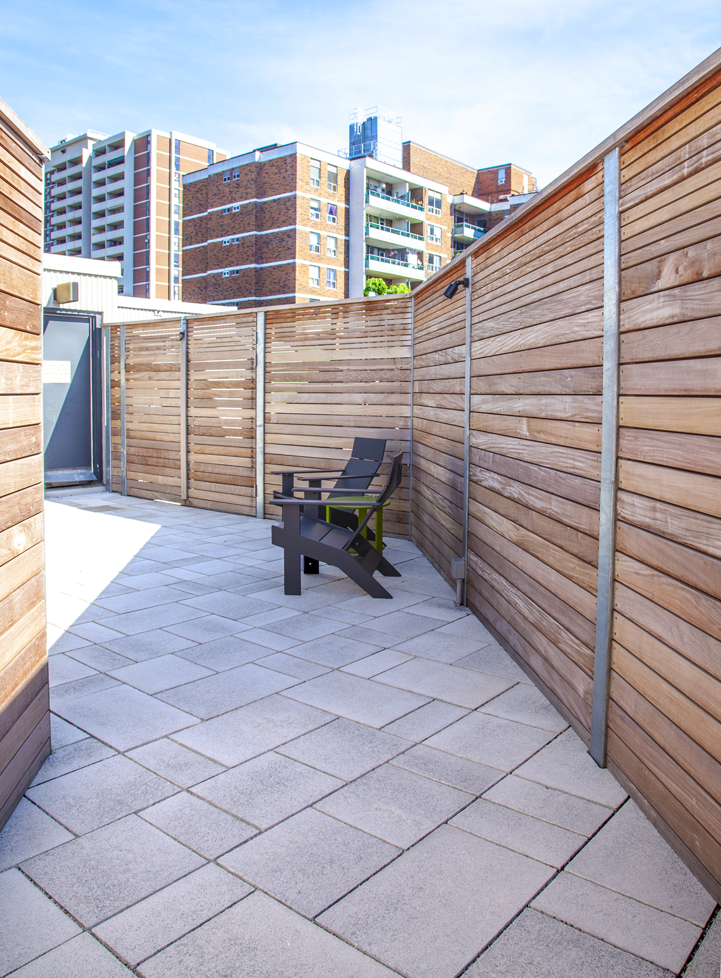 130 Carlton roof deck features Unilock Umbriano slabs in Winter Marvel, privacy walls, and outdoor amenities.