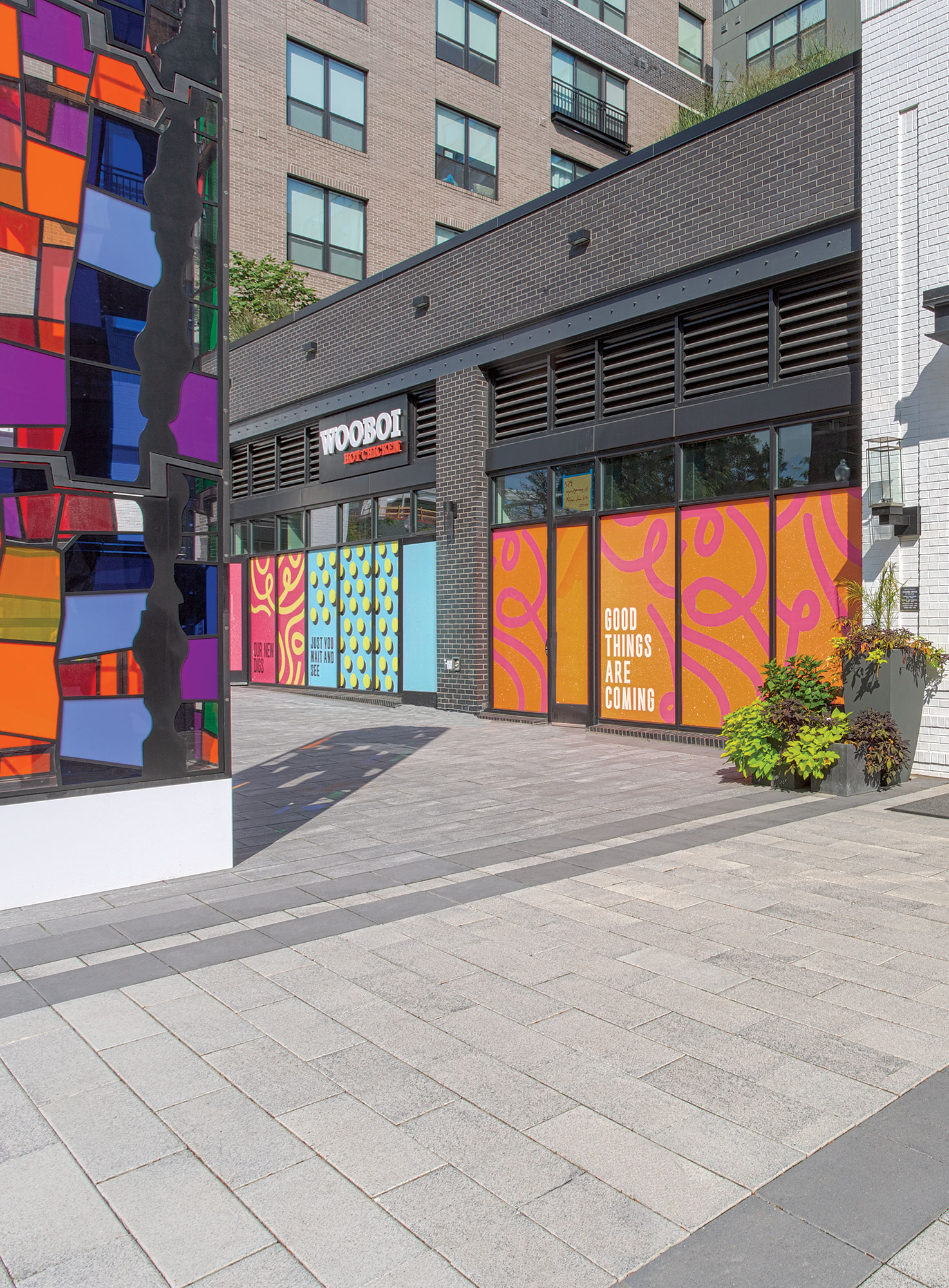 A vertical stained glass pillar disrupts the otherwise muted tones of tri-colored Umbriano pavers outside of Gables Old Town North.