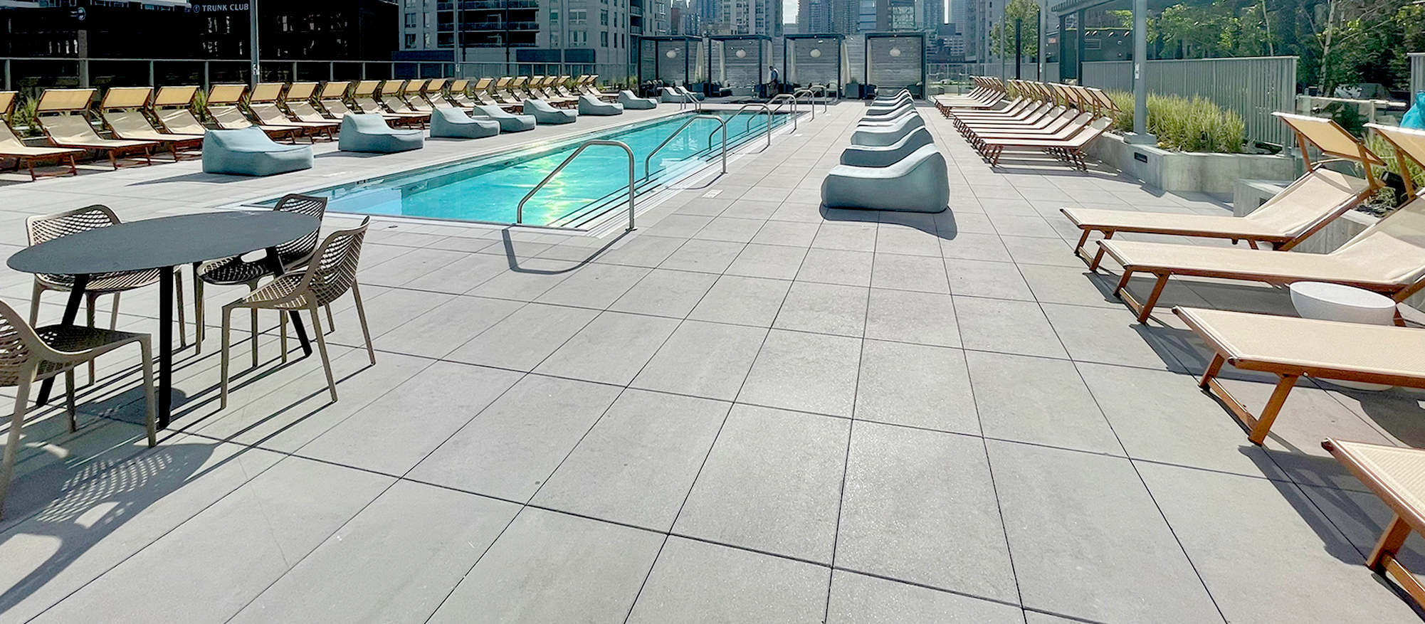 A view of the 369 W Grand pool deck featuring the Chicago skyline and paved with Unilock Beacon Hill Smooth XL in the color opal.