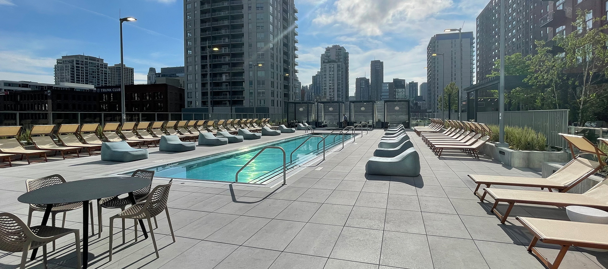 A view of the 369 W Grand pool deck featuring the Chicago skyline and paved with Unilock Beacon Hill Smooth XL in the color opal.